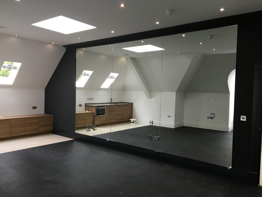 Frameless glass wall dividing loft conversion in Croydon